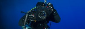 An underwater scuba diver with a camera