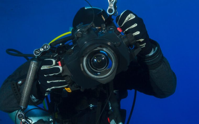An underwater scuba diver with a camera